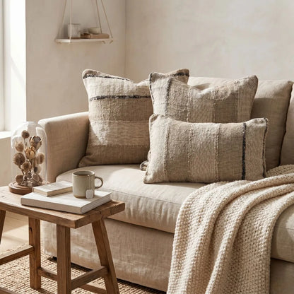 Beige sofa with textured pillows and a wooden side table in a cozy living room.