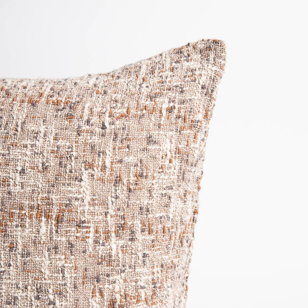 Textured pillow with a neutral color palette on a light background