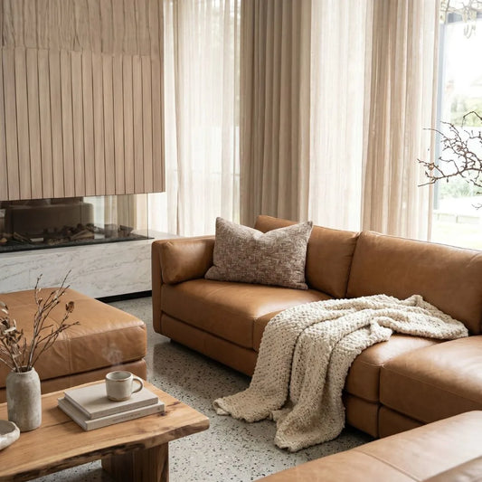 Cozy living room with brown leather sofa, wooden coffee table, and decorative elements.