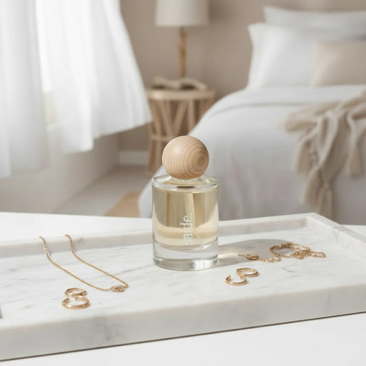 Perfume bottle with wooden cap on a marble tray in a bedroom setting