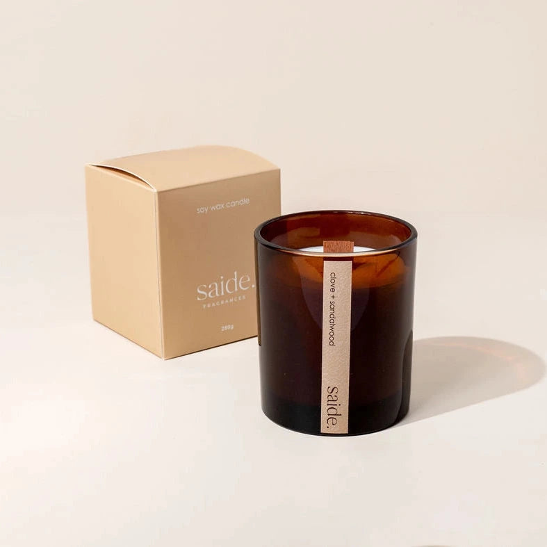 Brown candle with a visible brand name on a beige background