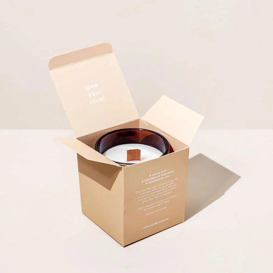 Candle in a cardboard box on a light background