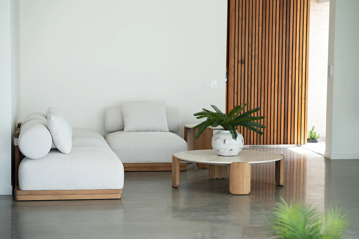 Modern outdoor patio with a white sectional sofa, coffee table, and decorative items.