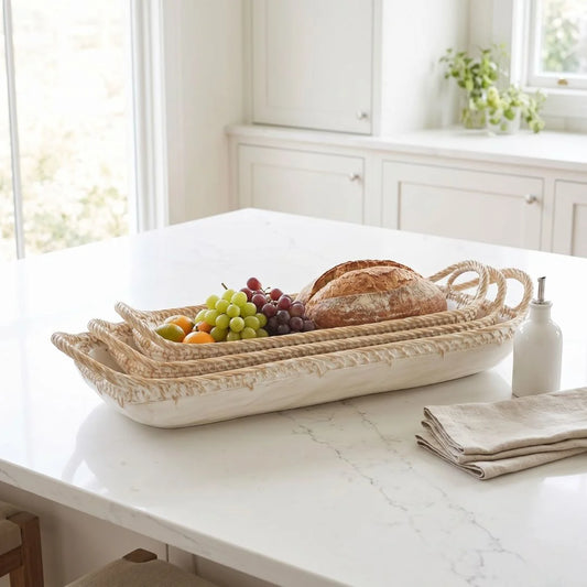 Woven bread basket with bread and fruits on a marble countertop in a bright kitchen.