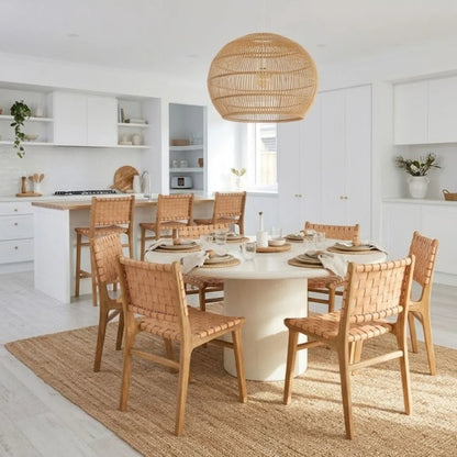 Dining area with wooden chairs and a round table in a bright kitchen.