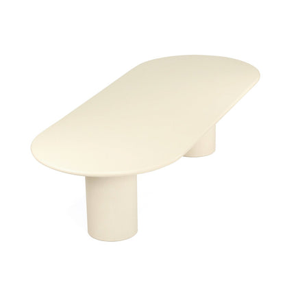 A minimalist modern coffee table with a smooth, rounded, elongated oval top and a single cylindrical pedestal base, shown in a warm cream or off-white color on a solid white background.