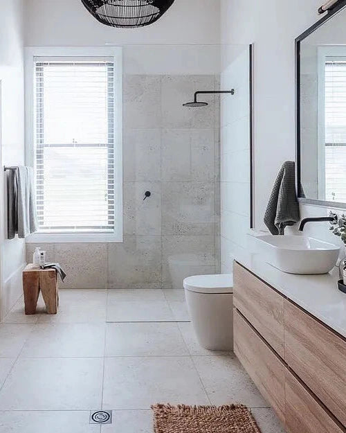 Modern bathroom with teak peg stool, wooden vanity, sink, and shower area. 