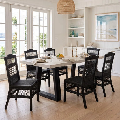 Dining room with a table and black chairs in a bright room.