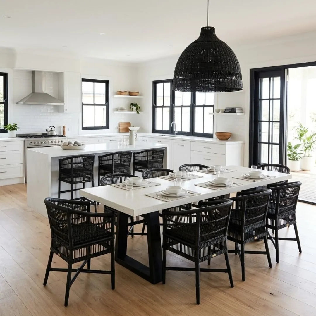Modern kitchen with a long dining table and black chairs.