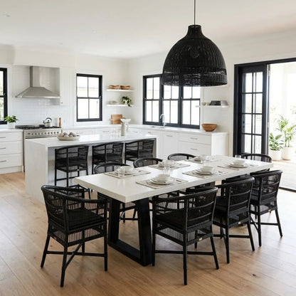 Modern kitchen with a long dining table and black chairs.