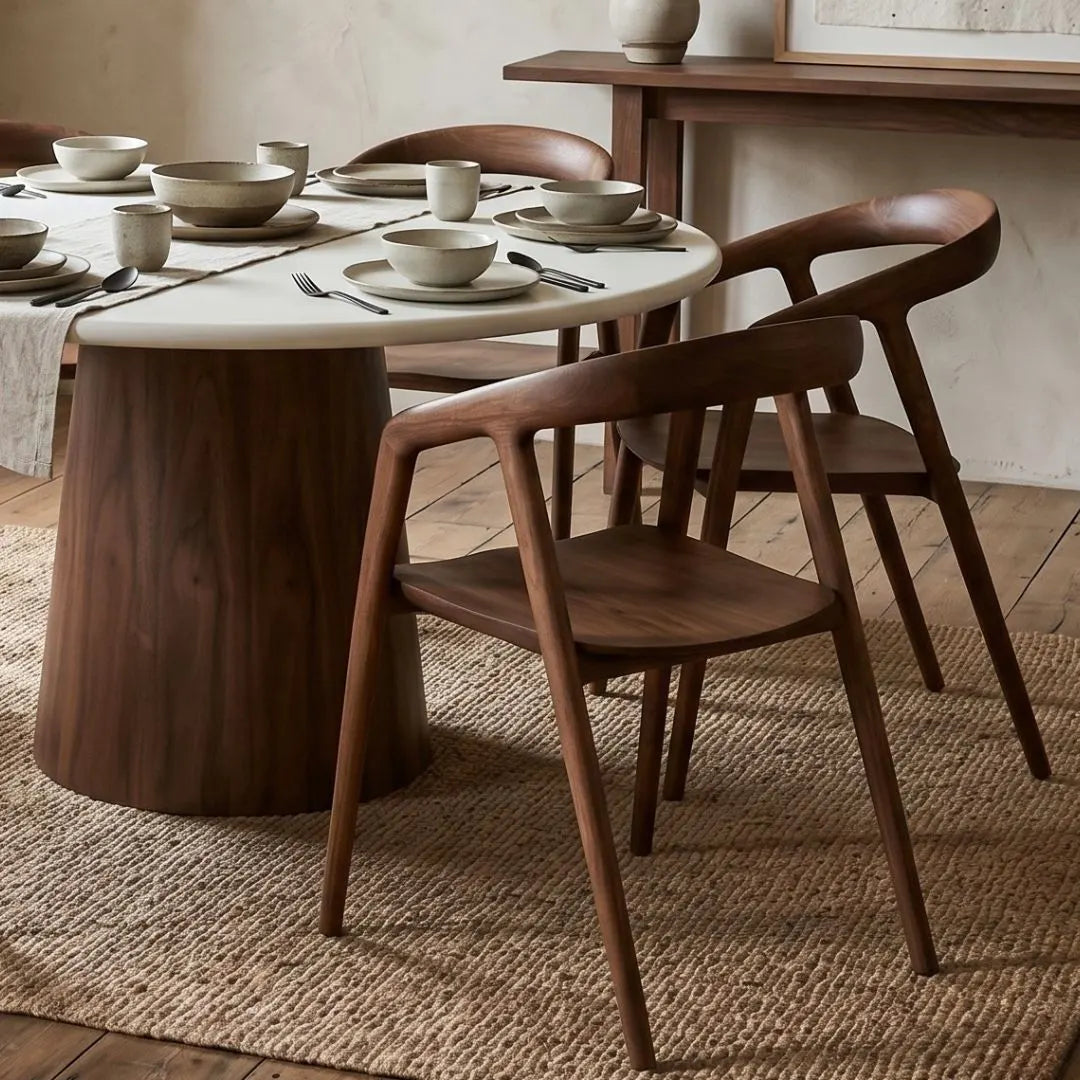Dining table set with wooden chairs in a rustic room.