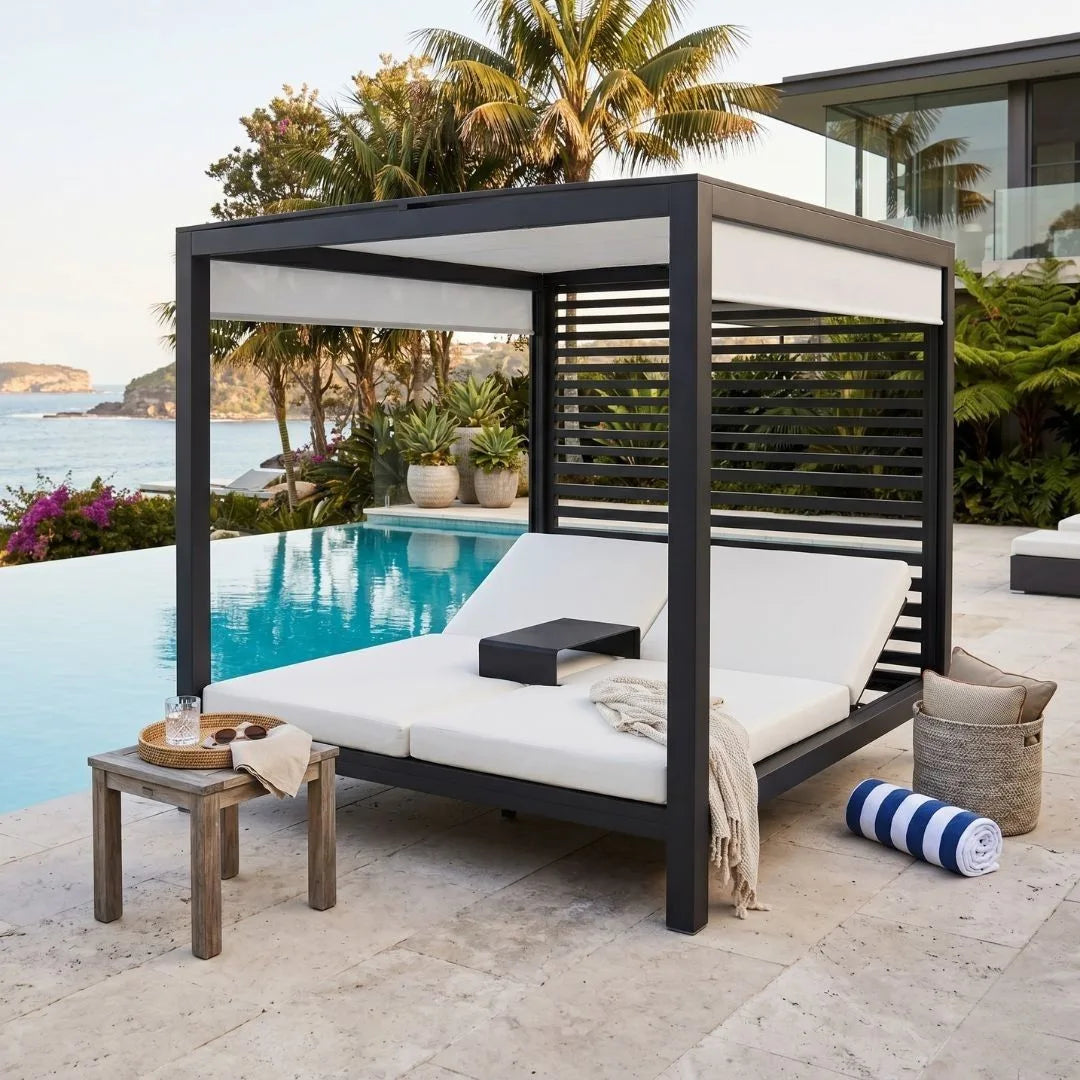 Outdoor lounge chair with canopy by a poolside with ocean view
