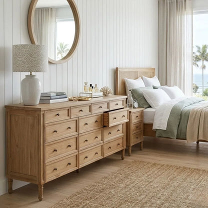 Wooden dresser in a bedroom with a bed and lamp.