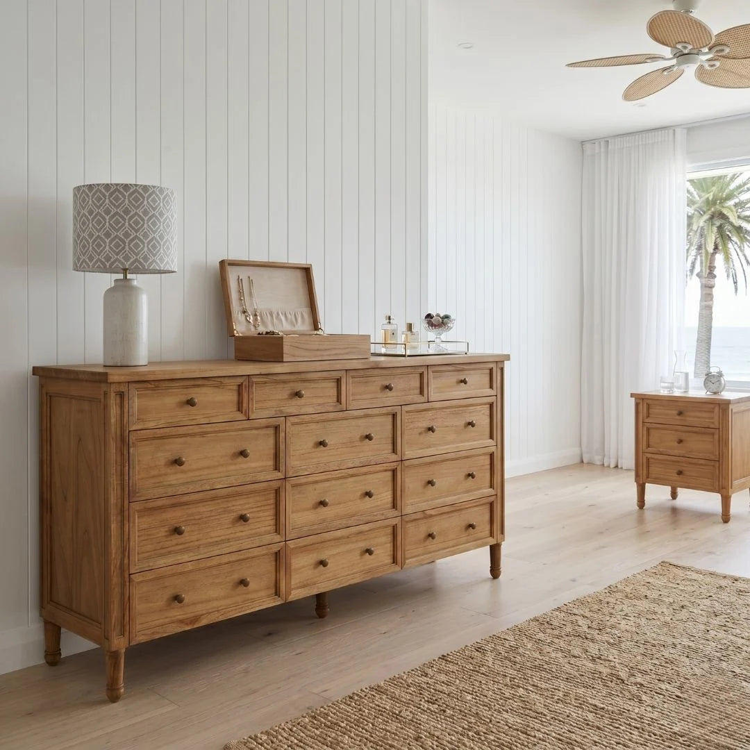 Wooden dresser with drawers in a room with a lamp and decor items.