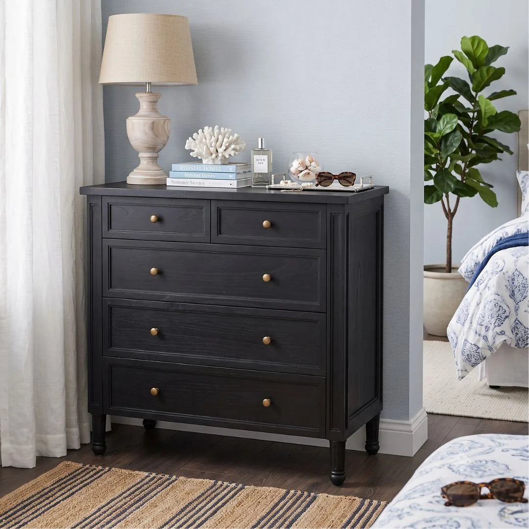 Black dresser with decorative items in a bedroom setting