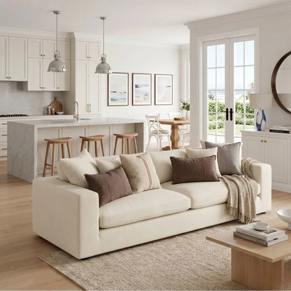 Modern living room with a white sofa, coffee table, and kitchen area.