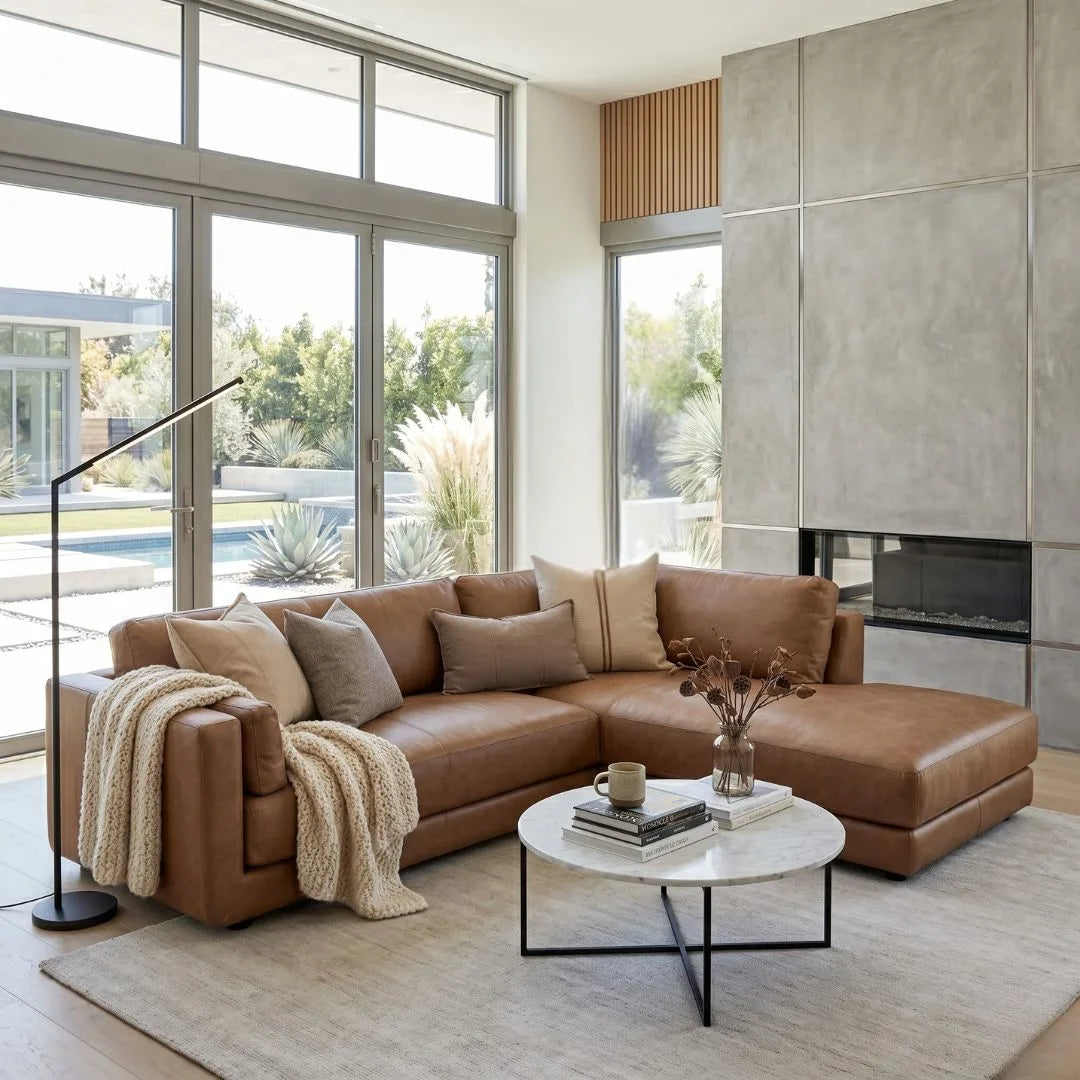 Modern living room with a brown sectional sofa, coffee table, and large windows.