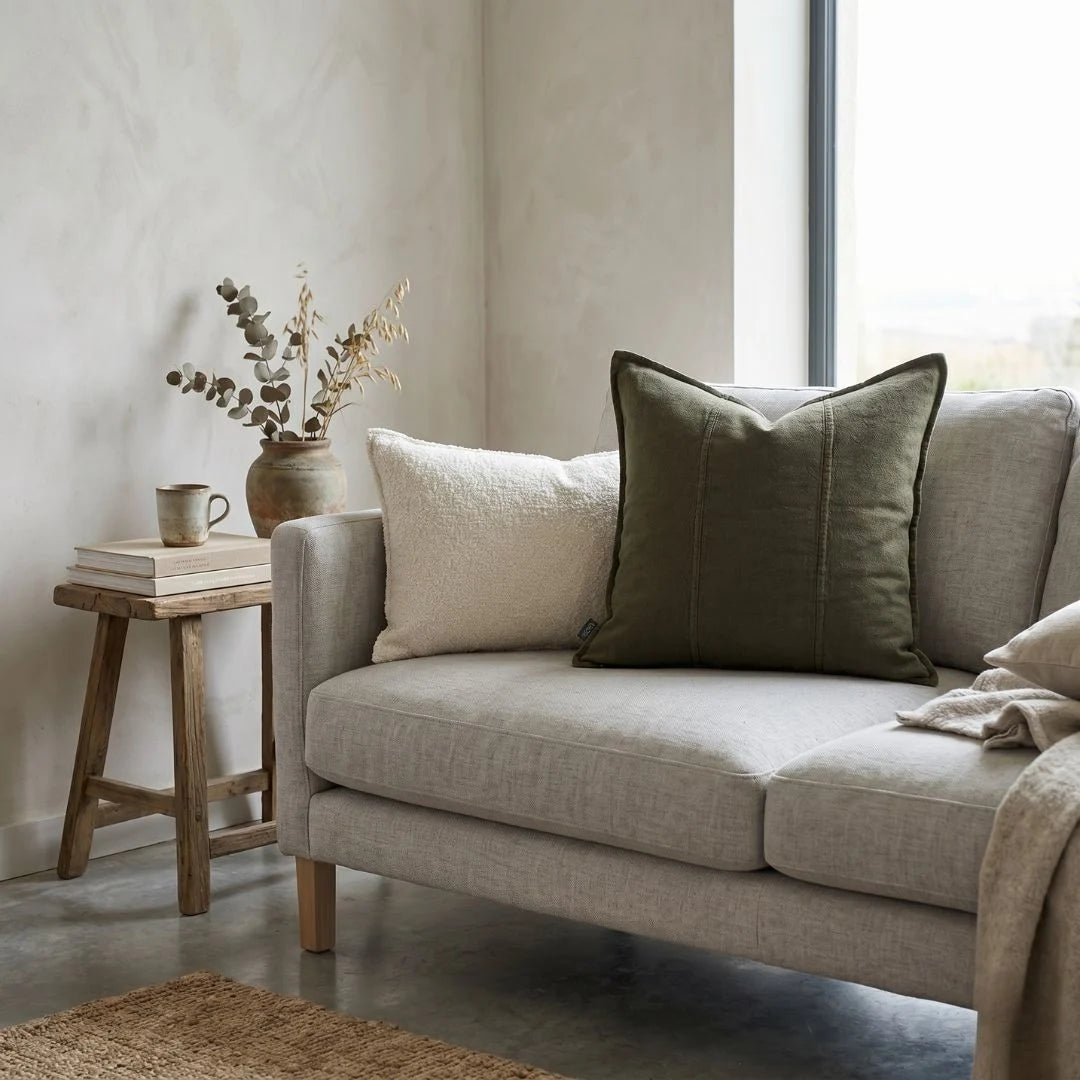 Beige sofa with decorative pillows in a living room setting