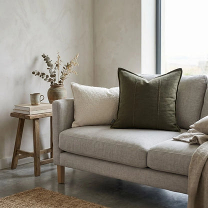 Beige sofa with decorative pillows in a living room setting