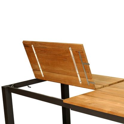 A modern outdoor dining table shown on a white background, featuring a light brown wood plank top and a black metal frame with an angled wooden backrest.