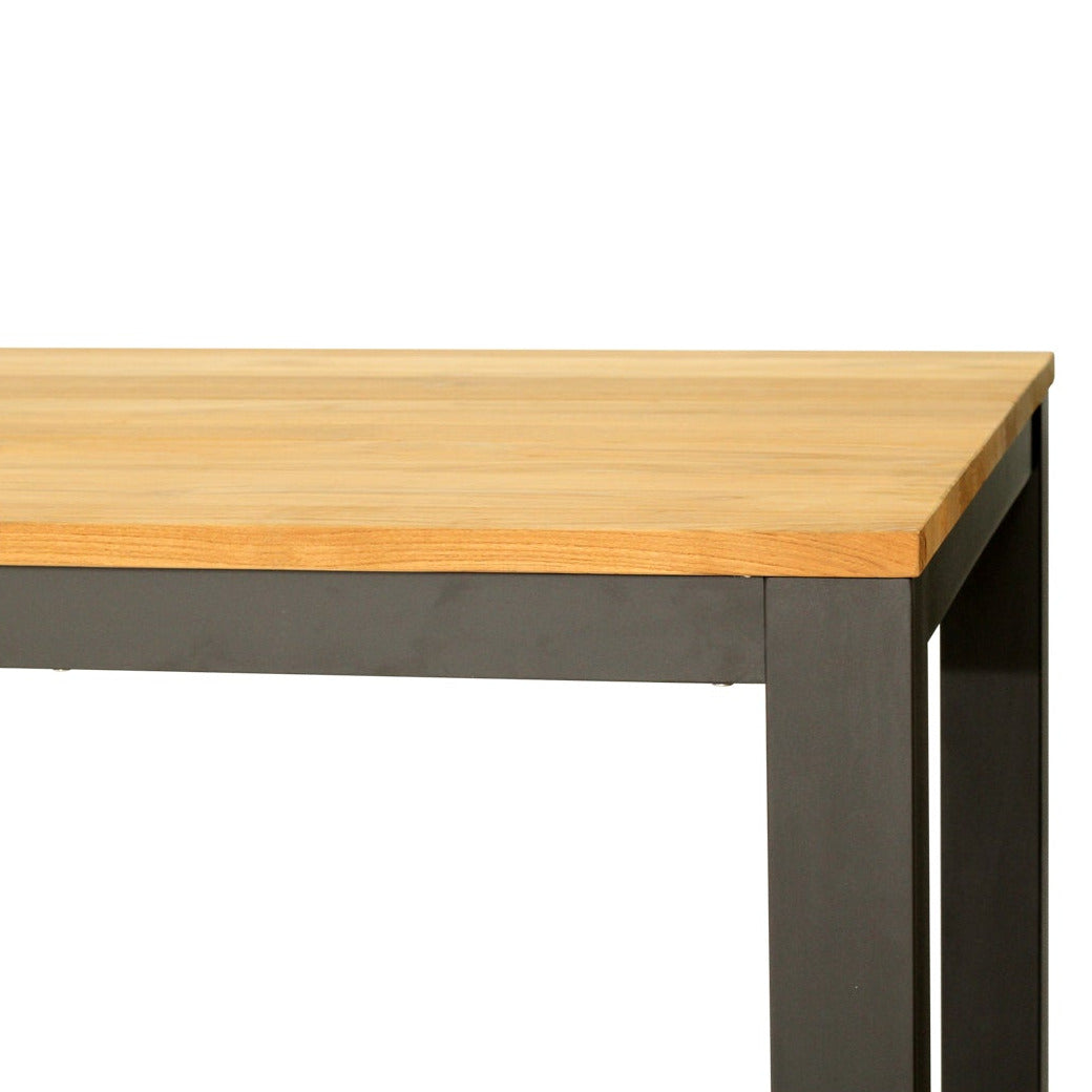 A close-up of a table corner showing a light natural wood top and a dark charcoal gray metal frame leg, isolated on a white background.
