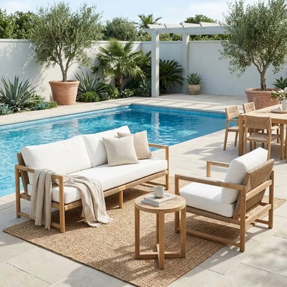 Outdoor patio set with wooden furniture and white cushions by a pool