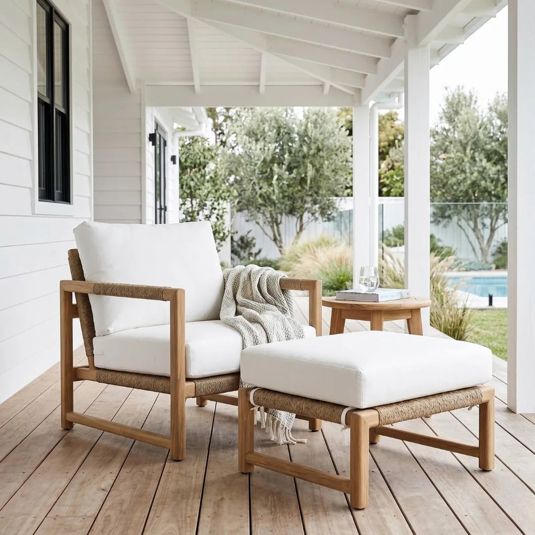 Outdoor furniture set with white cushions on a wooden deck.