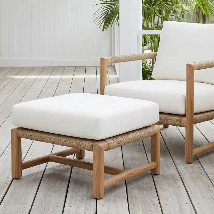 Wooden outdoor furniture set with white cushions on a wooden deck.