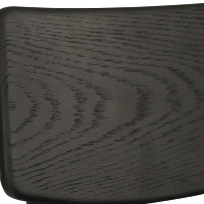Close-up of a dark wood chair back showing the grain pattern and texture of a black or very dark brown finish.
