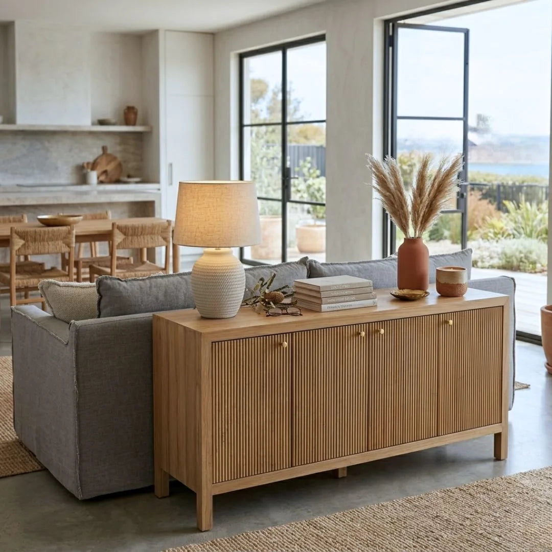 Living room with a wooden sideboard, gray sofa, and decorative items.