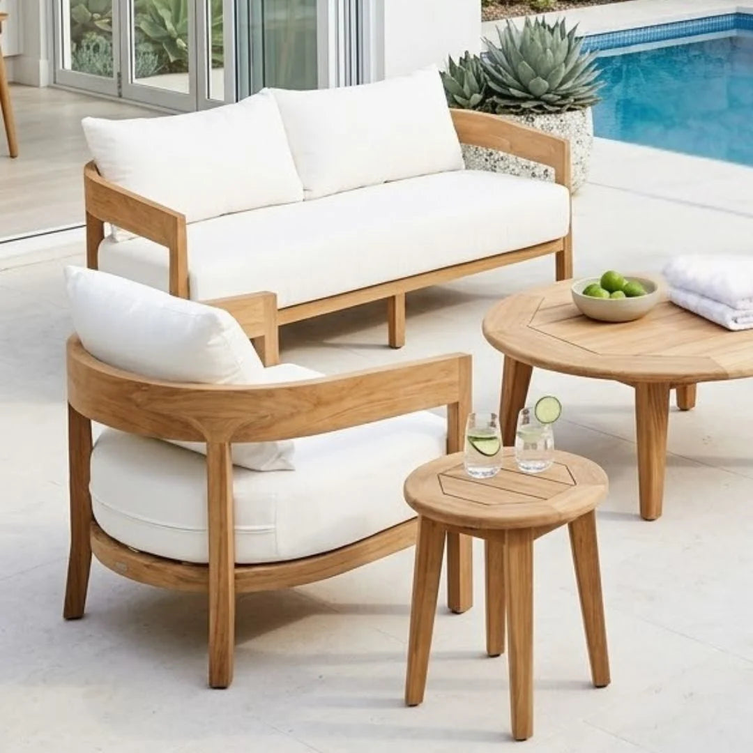Wooden outdoor furniture set with white cushions by a pool.