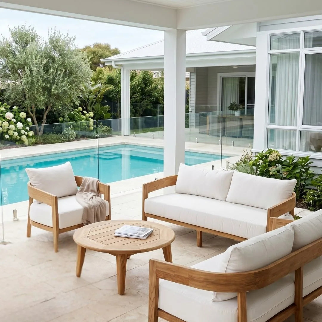 Outdoor patio with wooden furniture and a pool in the background