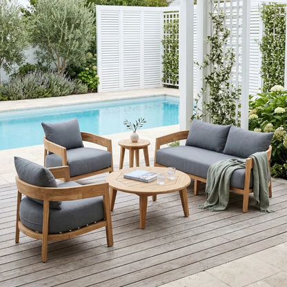 Outdoor furniture set with wooden frames and gray cushions by a poolside.