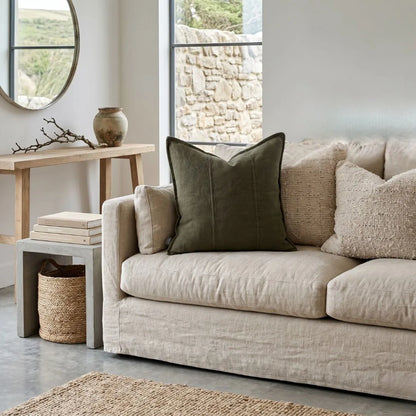 Beige sofa with decorative pillows in a living room setting.