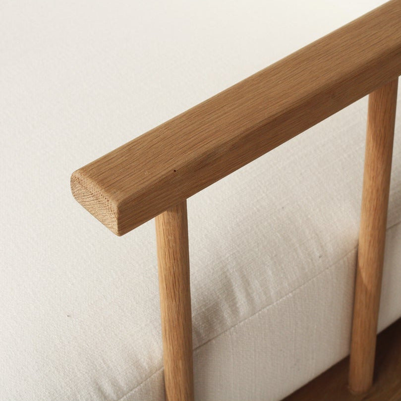 Wooden bed frame with a white mattress on a plain background