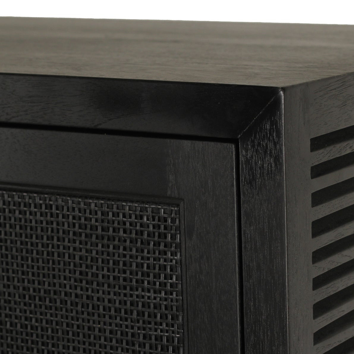 Close-up of a black wooden cabinet corner showing a slatted side panel and a dark mesh front door against a white background.