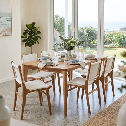 Dining room with teak rectangle table and Otis white leather and teak dining chairs, set for a meal with plates and cutlery.