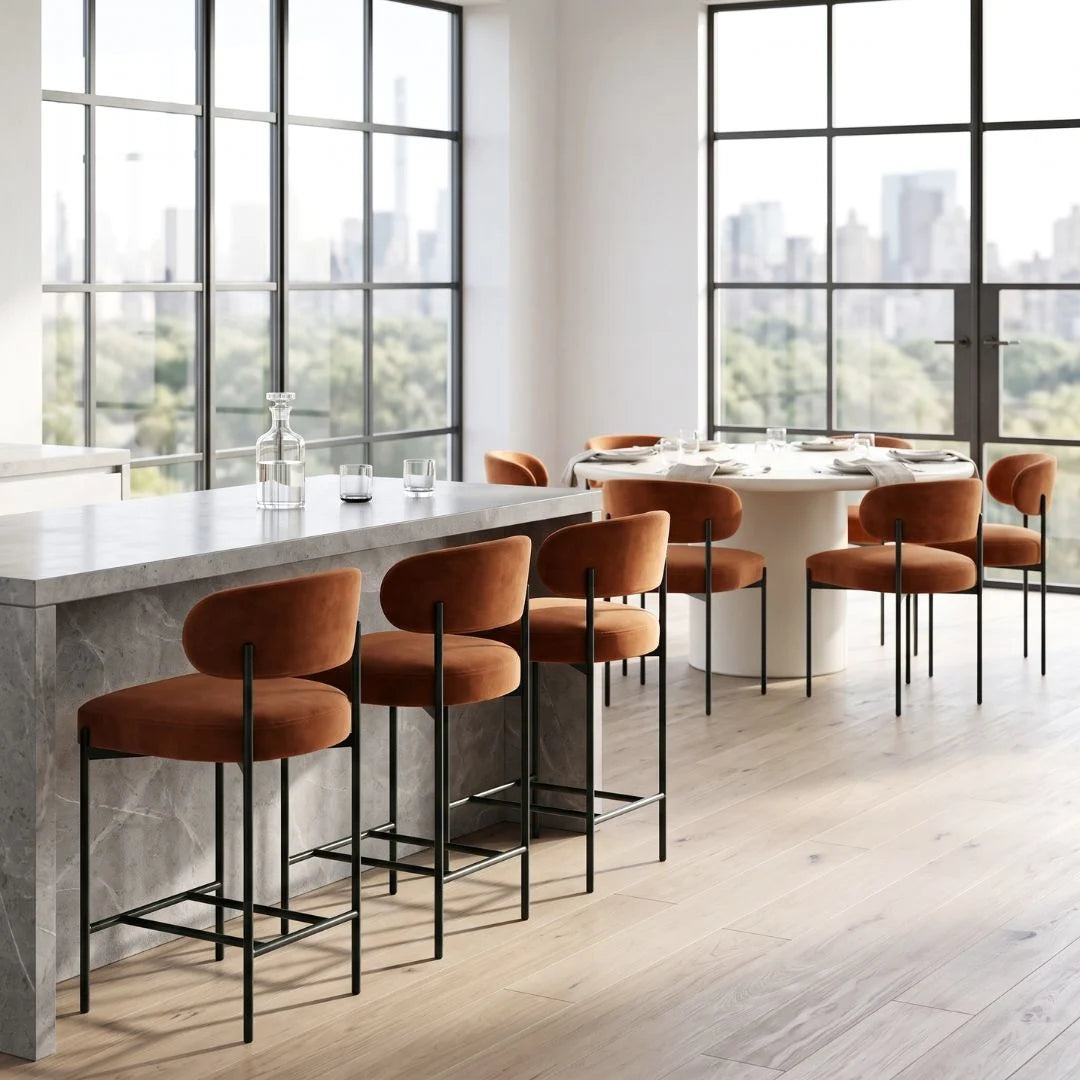 Modern kitchen with marble island and orange bar stools, large windows with city view.