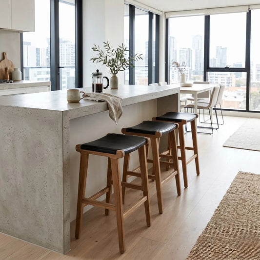 Sun Republic black leather and teak counter stools at an kitchen island bench in a modern apartment