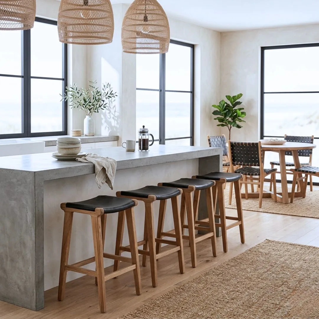 Sun Republic black leather and teak counter stools at an kitchen island bench in a modern home