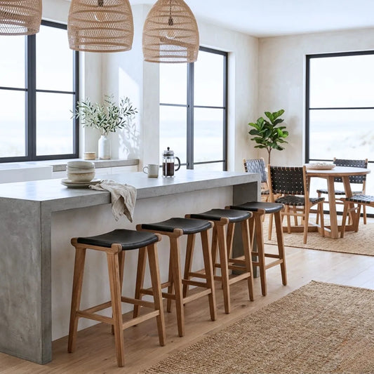 Sun Republic black leather and teak counter stools at an kitchen island bench in a modern home