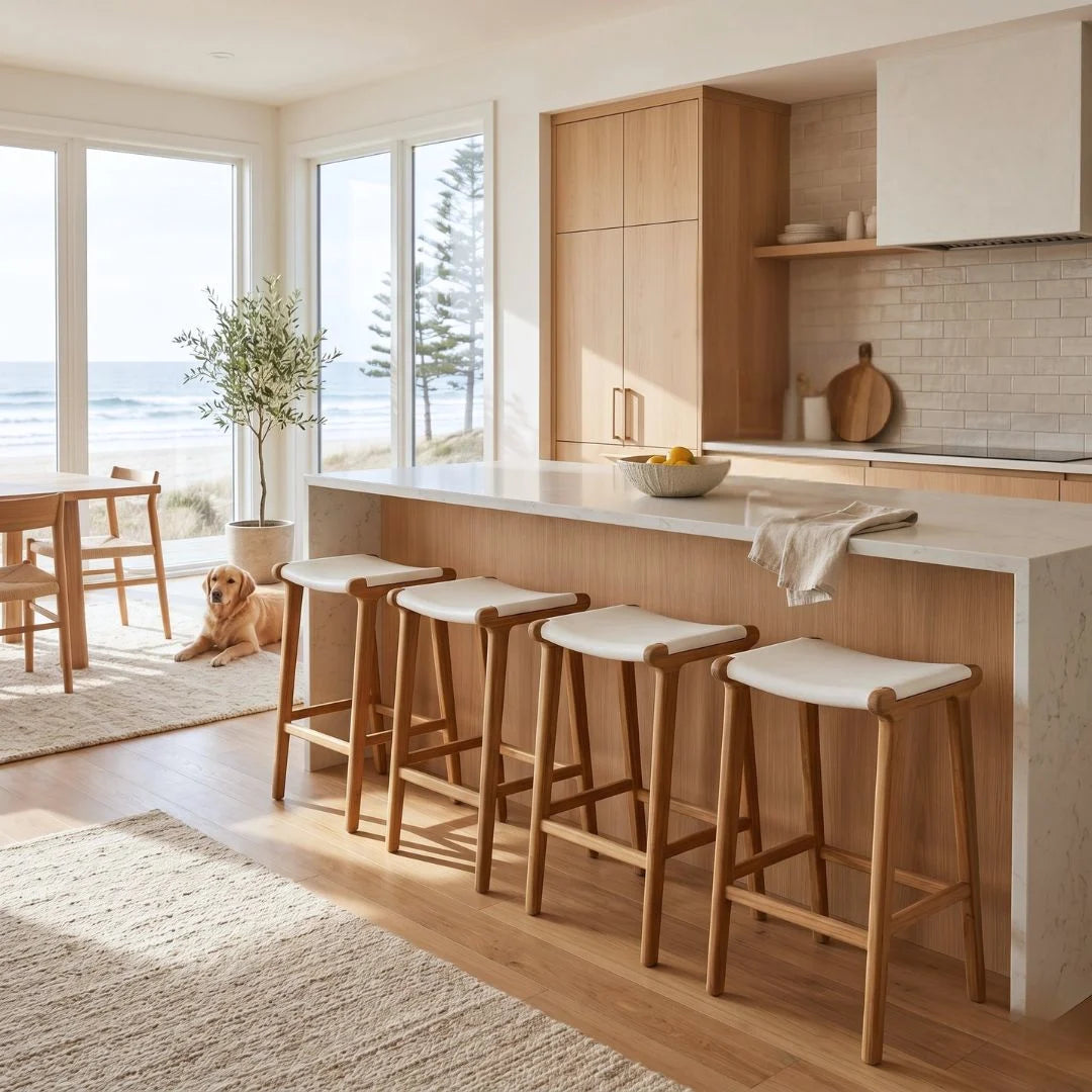 Modern kitchen with white island bench with white leather and teak counter stools