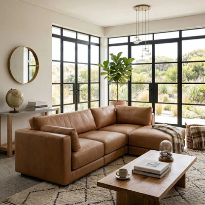 Modern living room with a brown sectional sofa, wooden coffee table, and large windows.