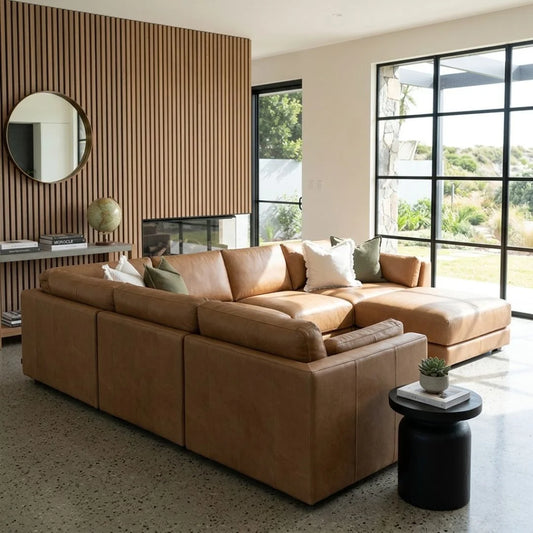 Modern living room with a large brown sectional sofa, decorative pillows, and a side table.