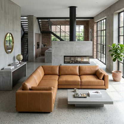 Modern living room with a brown leather sectional sofa, coffee table, and large windows.