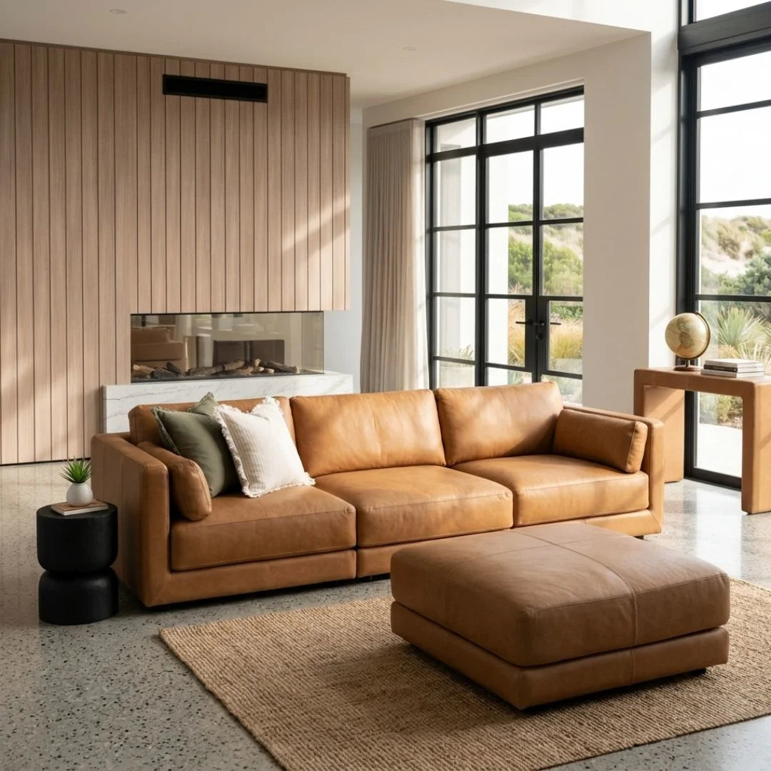 Modern living room with a brown leather sectional sofa and ottoman.
