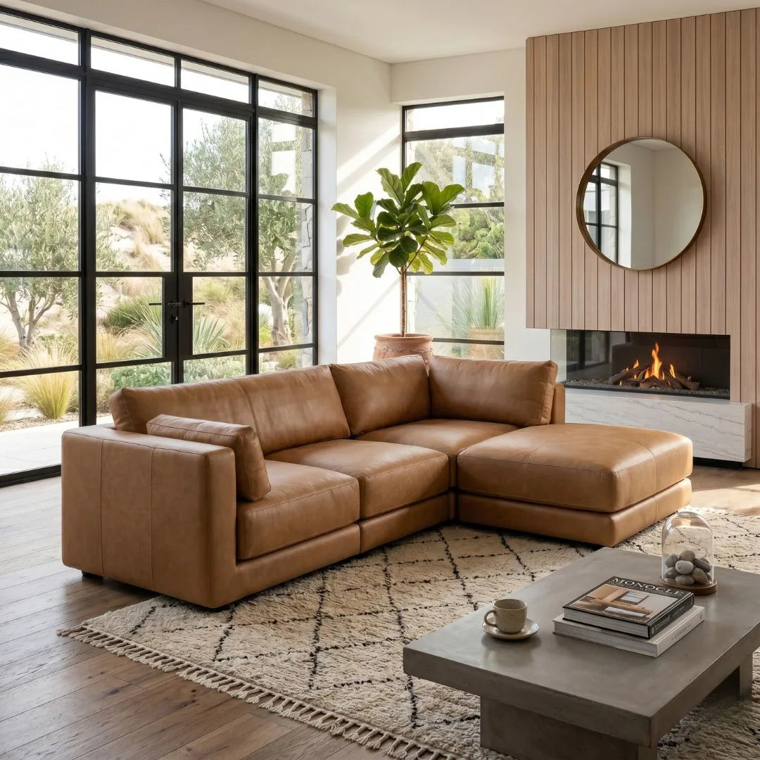 Modern living room with a brown leather sectional sofa, coffee table, and fireplace.