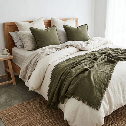 Bedroom with a bed featuring green and beige bedding and pillows.