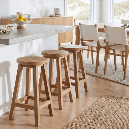 Sun Republic round teak counter stool in a row of three at a kitchen island bench in a modern light and bright kitchen