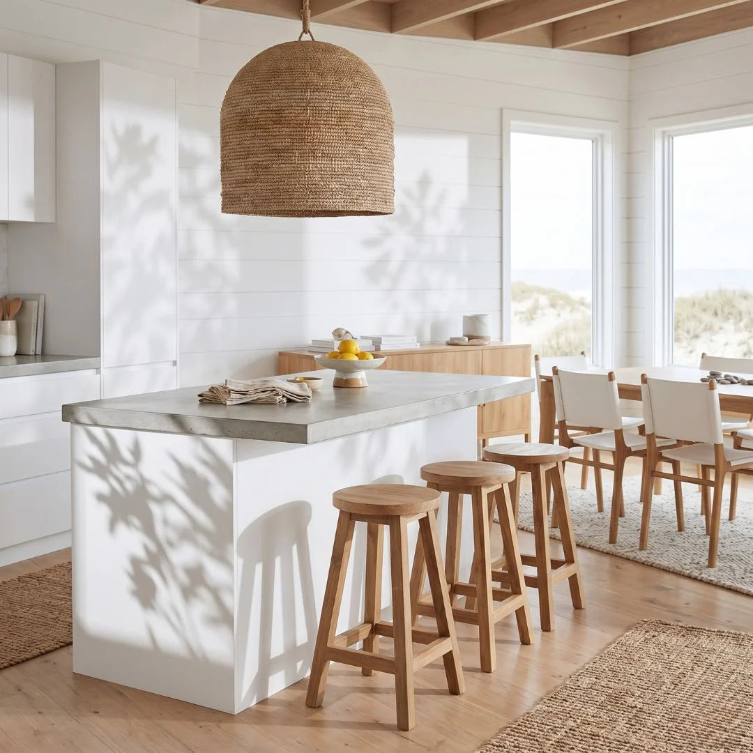 Sun Republic round teak counter stool in a row of three at a kitchen island bench in a open plan modern light and bright kitchen and dining room